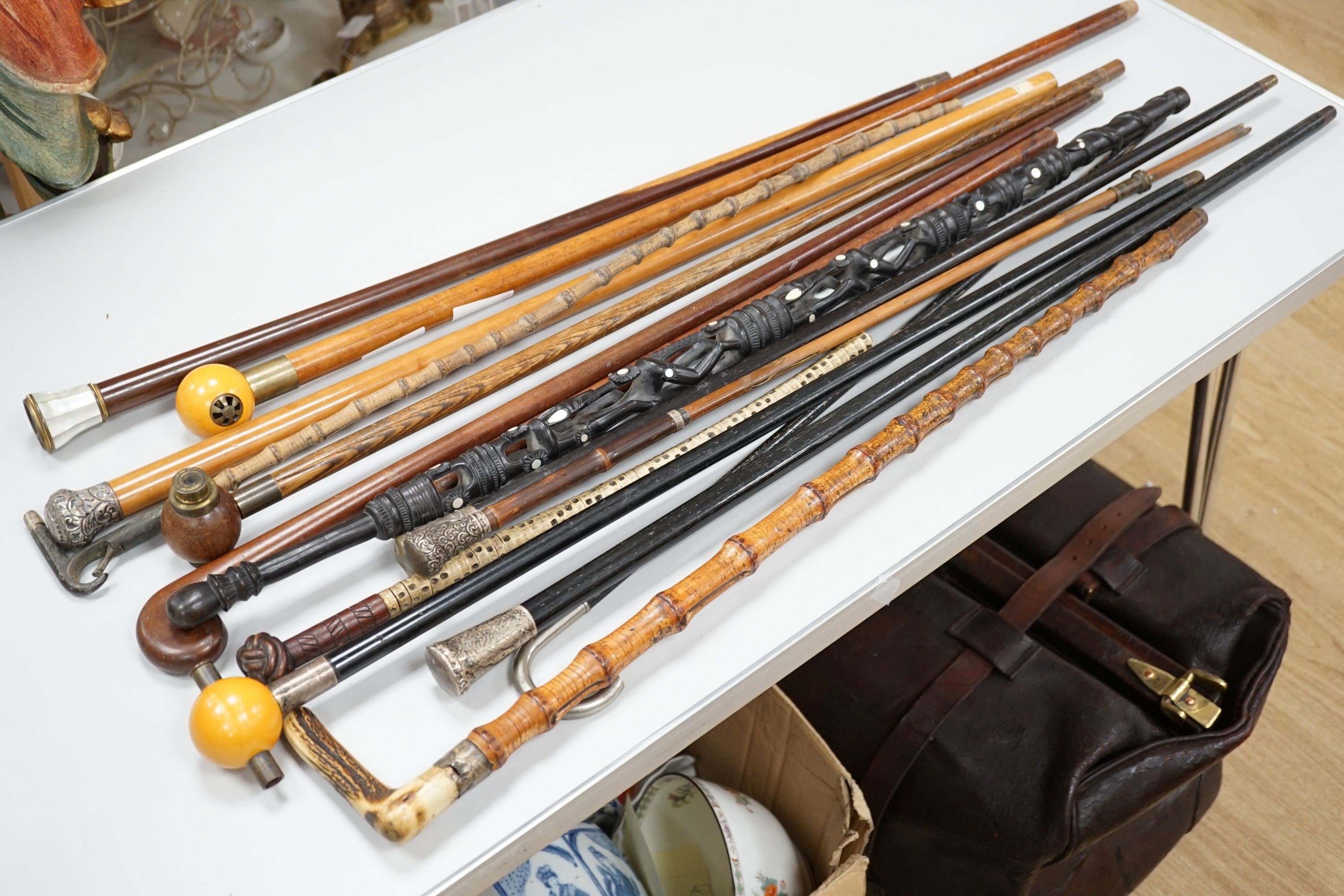 A collection of fifteen assorted walking sticks and canes, many silver mounted